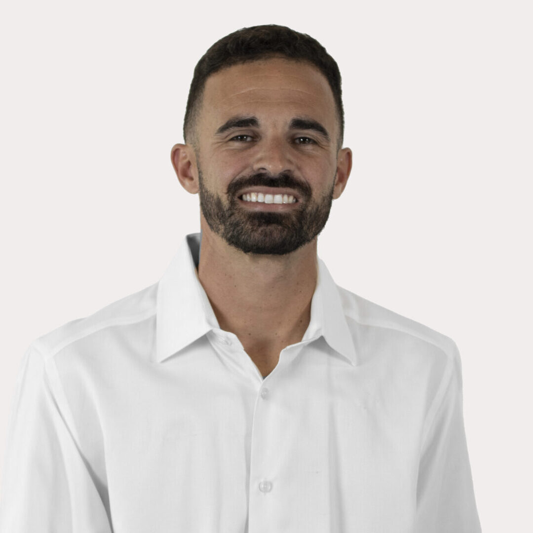 Smiling man wearing a white shirt.