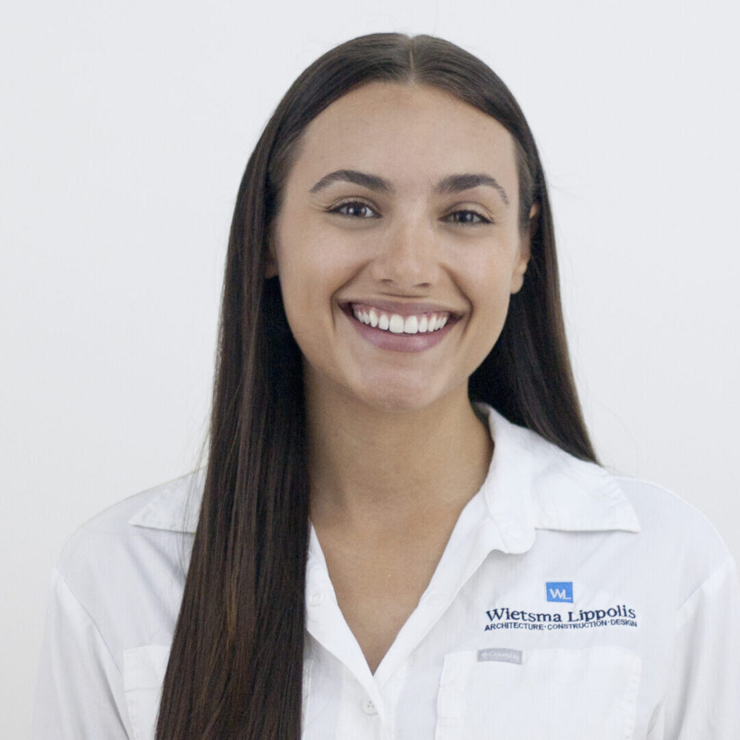 Smiling woman in white shirt with logo.