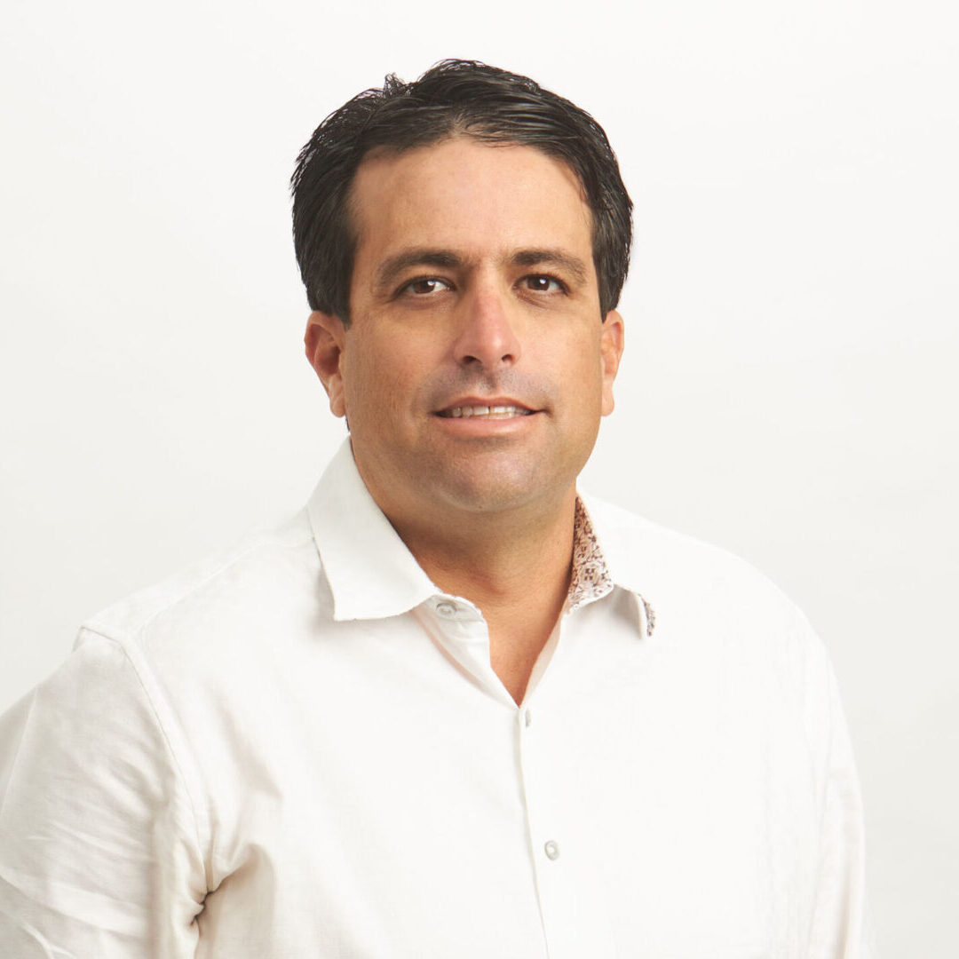 A man in white shirt standing next to wall.