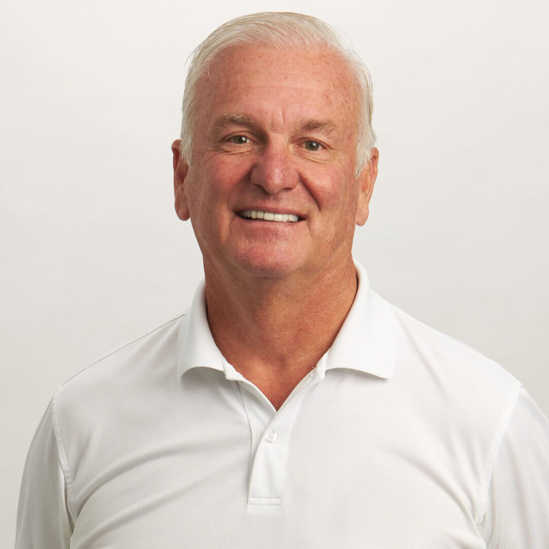 A man with white hair and a white shirt.