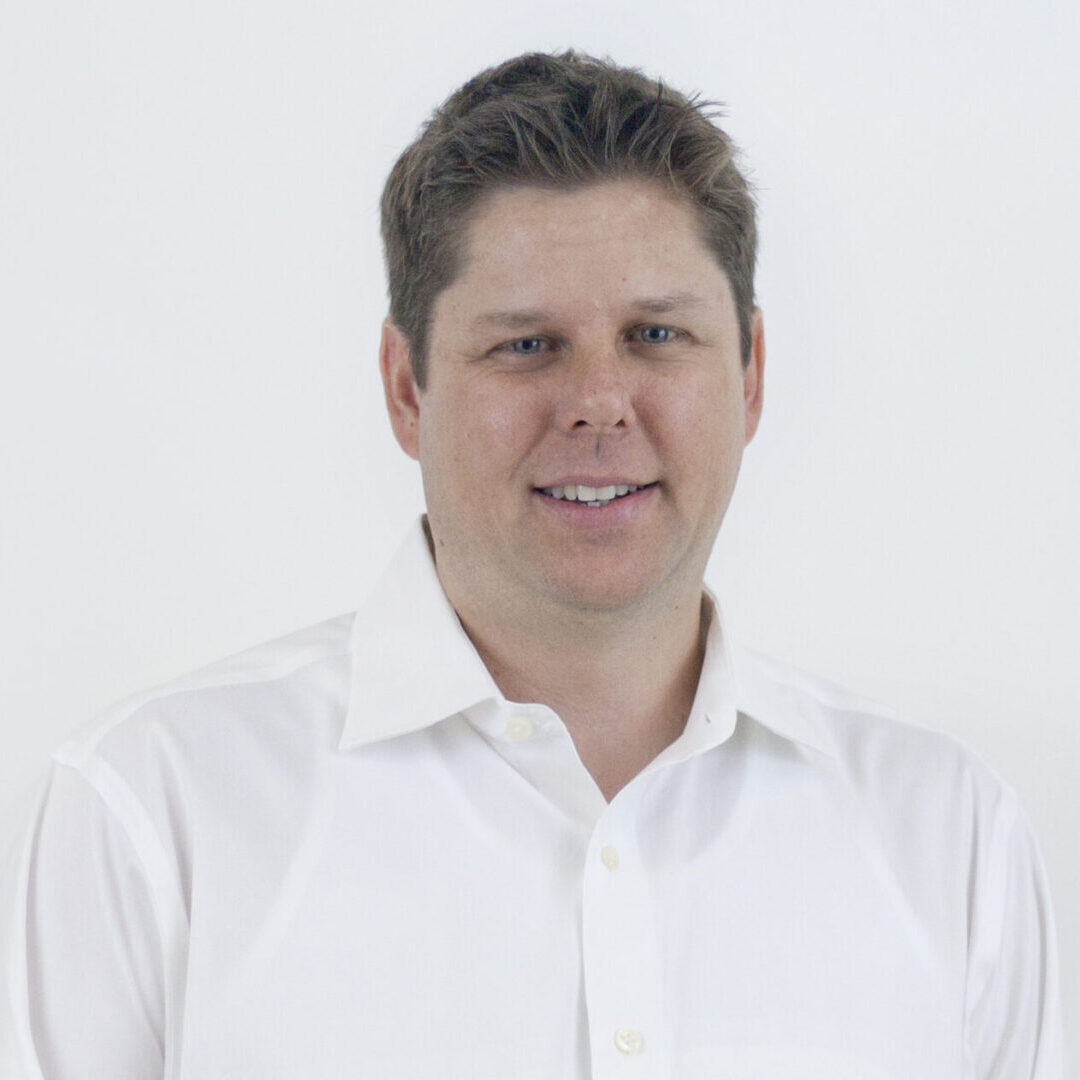 Smiling man wearing a white shirt.