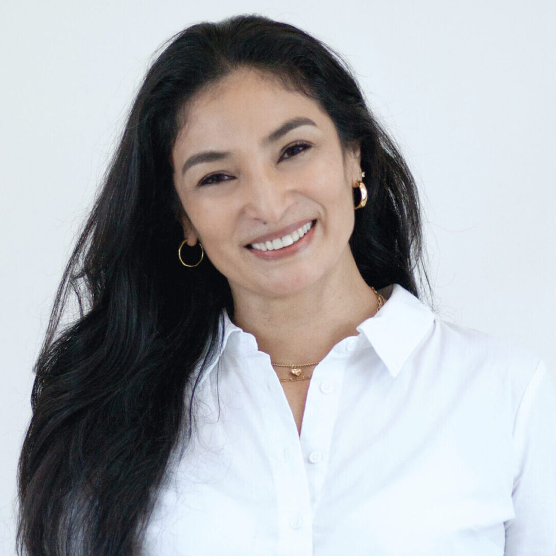 A woman with long black hair wearing a white shirt.
